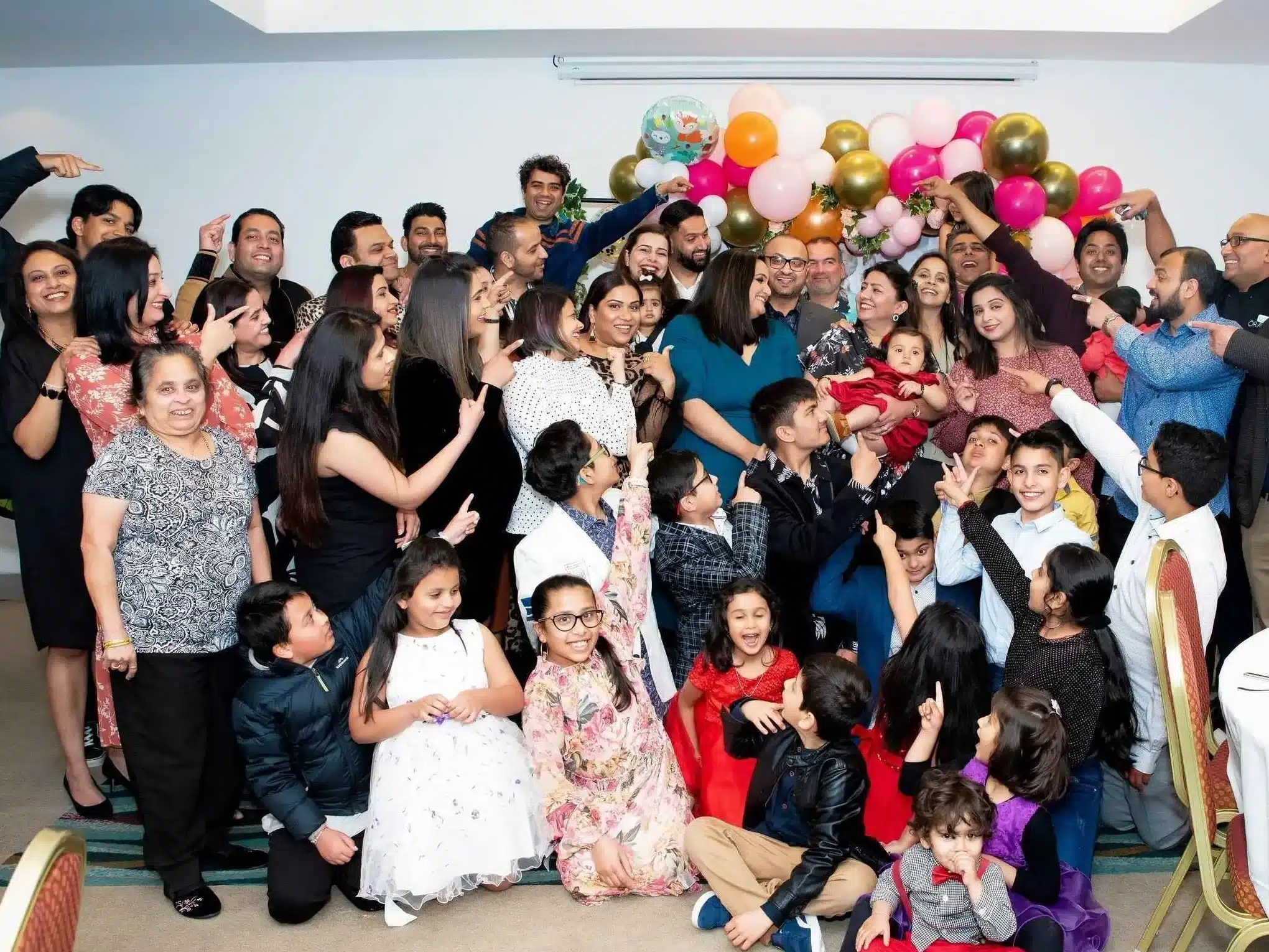Celebrating the Birthday Girl: A group photograph at a birthday party in Wellington, where all members joyfully point towards the birthday girl