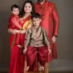 Captivating family photography portraying a well-coordinated maroon-themed family, including parents and two kids, against a warm brown background at Studio Wellington, New Zealand