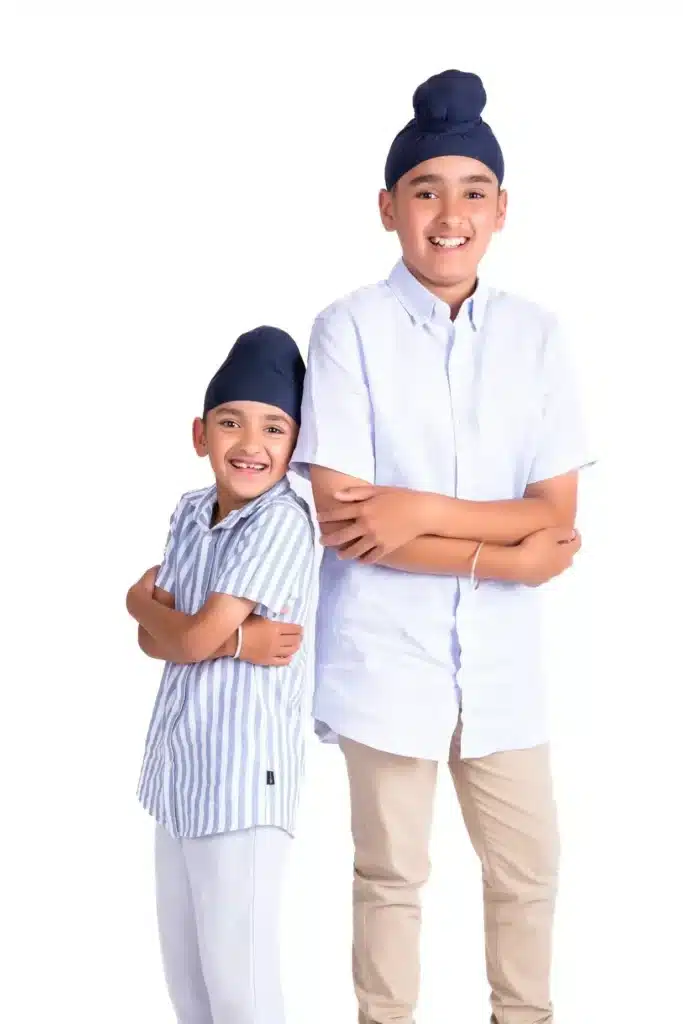 Two smiling brothers posing together during a studio kids photoshoot by Ruchika Jain Photography in Wellington.