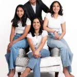 Radiant family portrait photography featuring ladies in white shirts and blue jeans, and a man wearing a black coat, all smiling against a pristine white background at Studio Wellington, New Zealand