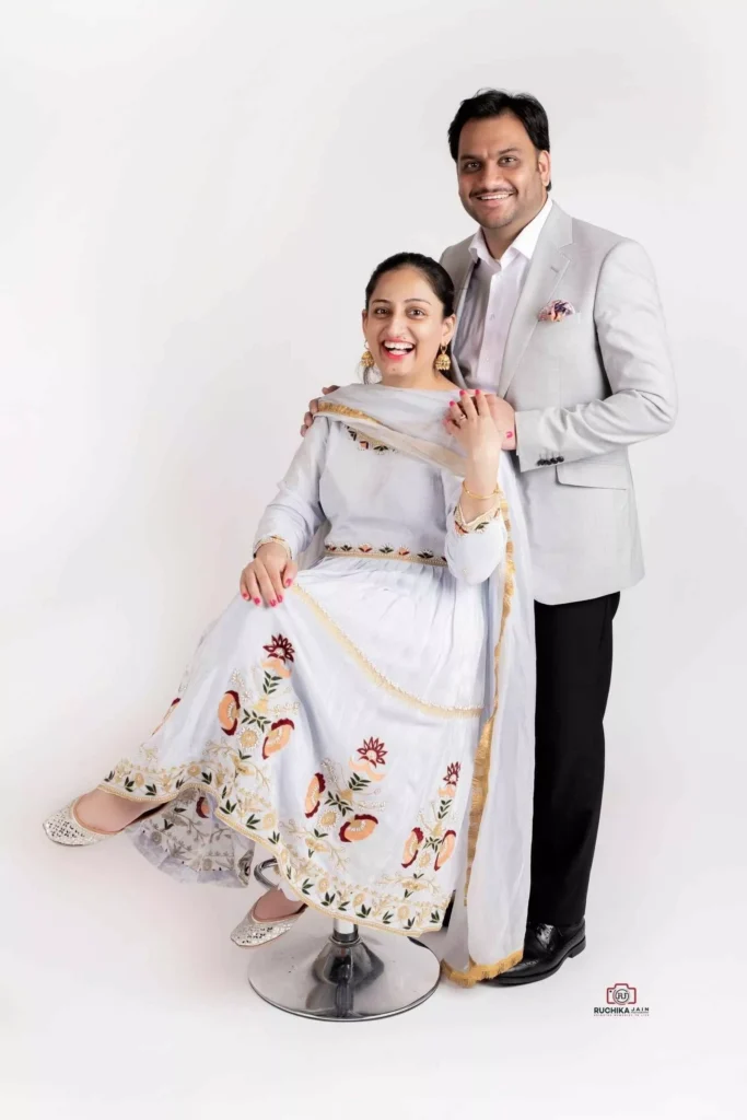 Stylish portrait of husband and wife in matching colored dresses, complemented by a matching background - Dress for Family Photoshoot Guide