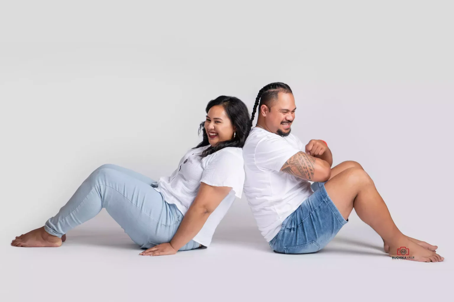 Playful and Healthy husband and wife portrait, having fun together with a serene light grey background - Dress for Family Photoshoot Guide