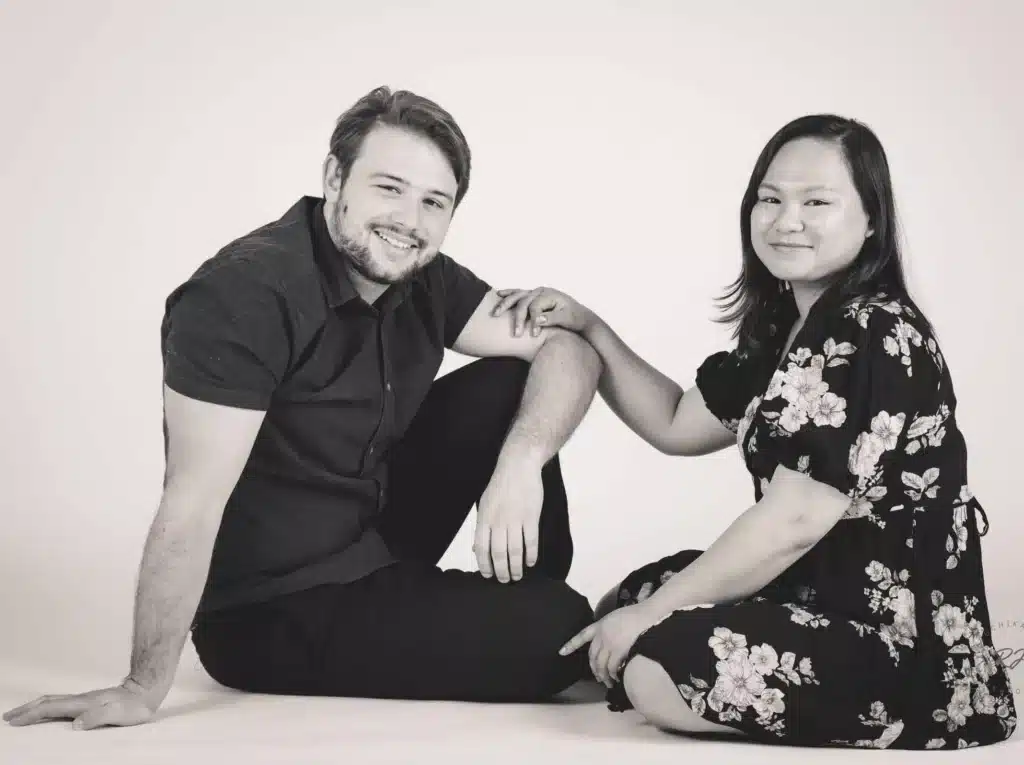 Joyful Candid Couple: A happy couple shares a candid moment, sitting together during a studio photoshoot at Ruchika Jain Photography Studio - Pre-wedding and Couple Photography, Wellington.