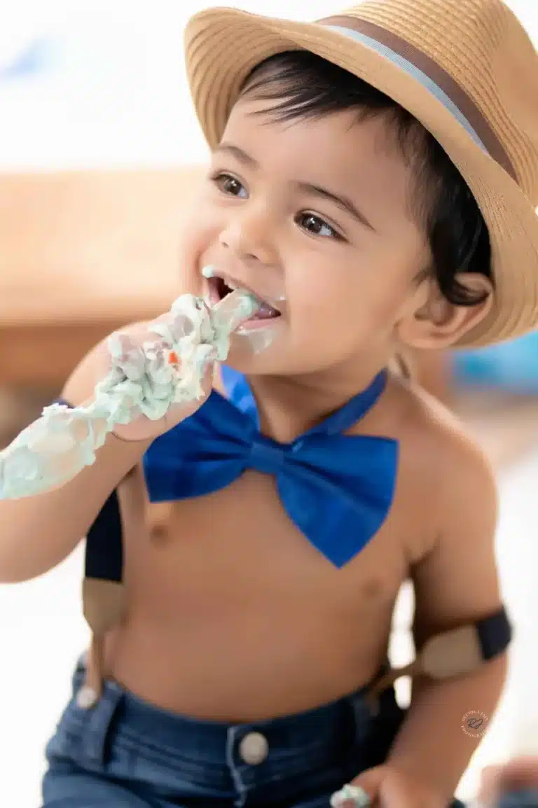 Cheerful toddler enjoying a cake smash experience captured by a skilled photographer
