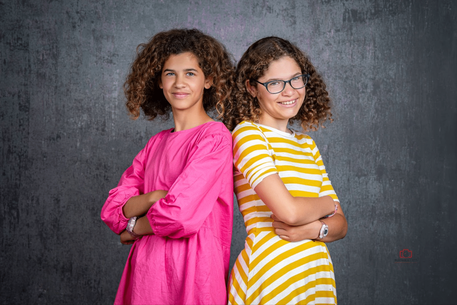 Creative sibling portrait session by Ruchika Jain Photography featuring two smiling girls posing confidently in bright outfits during a professional kids photography shoot